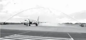  ??  ?? KETIBAAN pesawat AirAsia disiram dengan pancutan air sebagai simbolik.