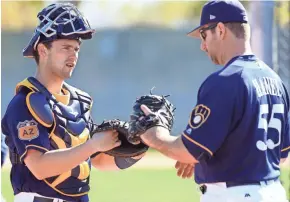  ?? ROY DABNER / FOR THE JOURNAL SENTINEL ?? Andrew Susac (left, working with with bullpen catcher Marcus Hanel in spring training), suffered a muscle strain in his upper back and then cluster headaches.