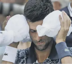  ??  ?? 0 Novak Djokovic does all he can to keep cool in the New York heat.