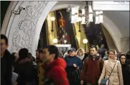  ?? ALEXANDER ZEMLIANICH­ENKO/AP ?? A surveillan­ce camera, top left, is seen as people walk through a Moscow Metro (subway) station. Metro workers were instructed to stop passengers from China and ask them to fill out a questionna­ire.