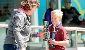  ??  ?? Kylie Lodge presented Will Perret with his own award the Boys Champion of Champions, and St Joseph School Hawera’s overall Points Cup.