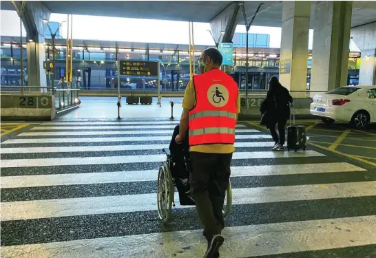  ?? CIPRIANO PASTRANO ?? Una persona en silla de ruedas en Madrid-Barajas es ayudada por el servicio de asistencia del aeropuerto