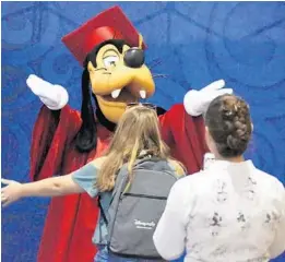  ?? RICARDO RAMIREZ BUXEDA/ORLANDO SENTINEL ?? Goofy hugs a Disney employee during an expo for the Disney Aspire program at the Coronado Springs Resort, on Sept. 28, 2018.