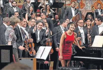  ?? ANTONI BOFILL / PALAU DE LA MÚSICA ?? Gustavo Dudamel, al centre, saludant al final del concert al Palau, amb la pianista Yuja Wang