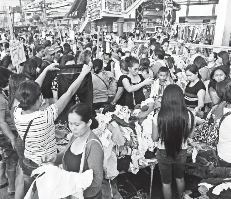  ?? MACKY LIM ?? UKAY-UKAY. A common scene at Bankerohan Public Market in Davao City every weekend as hundreds of buyers flock to buy second hand garments at a low price.