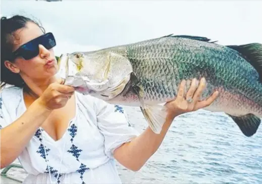  ??  ?? Ebony Williams with a 90cm barra caught off Dundee — released after a few photos