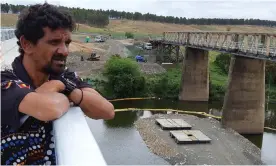  ?? Photograph: Christine Tondorf ?? Terrence Robinson from the Jana Ngalee land council looks out over the timber bridge at Tabulam as crews and machinery arrive for the demolition on Thursday.