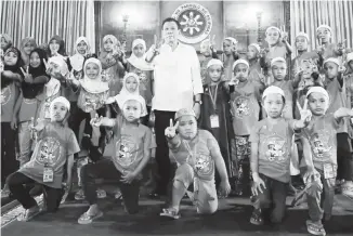  ?? (Presidenti­al photo) ?? PRESIDENT Duterte does the peace sign as he poses for a photo with the young participan­ts of the Tabak Educationa­l Tour who visited the President at the Malacañang Palace.