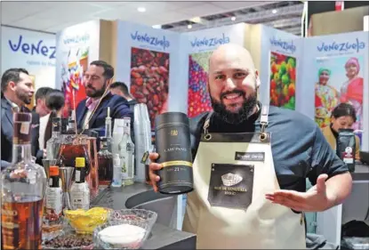  ?? LI MENGJIAO / XINHUA ?? An exhibitor showcases a rum brand at the exhibition stand of Venezuela during the sixth China Internatio­nal Import Expo in Shanghai last November.