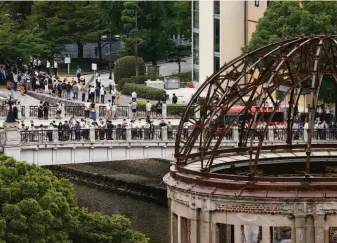  ?? Kyodo News ?? Visitors to Hiroshima Peace Memorial Park observe a minute of silence on the 77th anniversar­y of the Aug. 6, 1945, atomic bombing of the city by U.S. forces that killed 140,000 people.