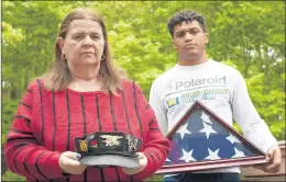  ?? MARY ALTAFFER/AP ?? Florence Hopp holds the hat her husband, Robert, wore every day as J.J. Brania-Hopp shows the U.S. flag the military presented them after his stepfather’s death last month.