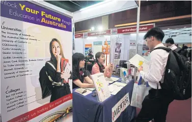  ??  ?? A student checks the details of a school in Australia at the Bangkok Post Career-Education Expo.