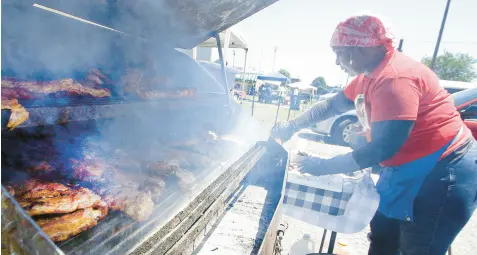  ?? JOHN SMIERCIAK/POST TRIBUNE PHOTOS ?? Robbin Davis of Rockin’ Robbins cooks up some rib tips and pulled pork during the Juneteenth Freedom Festival at the Gary City Hall on Saturday.