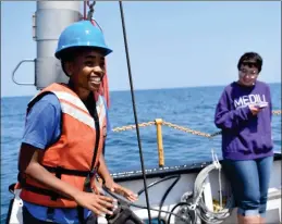  ?? Johnny Ford, Shedd Aquarium ?? Carmen Jones, 16, a member of the student-led Aquarius Project, works aboard the Neeskay in Lake Michigan in July.