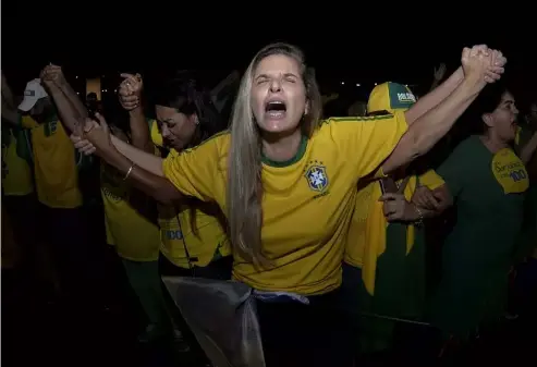  ?? ?? Supporters of Jair Bolsonaro, who is running for another presidenti­al term, pray as they wait for election results in Brasilia, Brazil, Sunday, Oct. 2, 2022 Ton Molina/AP