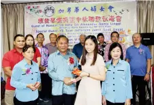  ?? ?? James Sandak, representi­ng Deputy Minister in the Premier’s Department Jefferson Jamit at the event, presents an education incentive to graduate Sii Siew Ping, as Wong (right), event organising chairman Tiong Kiew Lan (left) and others look on.