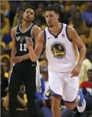  ?? BEN MARGOT — THE ASSOCIATED PRESS ?? Golden State Warriors’ Klay Thompson, right, celebrates a score against San Antonio Spurs’ Bryn Forbes, left, during the second half in Game 1 of a first-round NBA basketball playoff series Saturday in Oakland