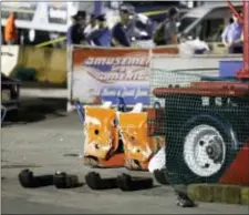  ?? BARBARA J. PERENIC — THE COLUMBUS DISPATCH VIA AP ?? Authoritie­s stand near damaged chairs of the Fire Ball amusement ride after the ride malfunctio­ned injuring several at the Ohio State Fair, Wednesday in Columbus, Ohio.