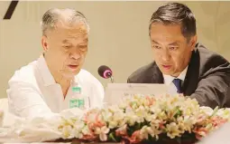  ??  ?? LT Goup, Inc. Chairman Lucio Tan (left) confers with son Michael Tan during the company’s annual stockholde­rs’ meeting at the Century Park in Malate, Manila yesterday.
