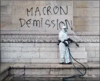  ?? AP/THIBAULT CAMUS ?? A worker prepares to clean graffiti from the Arc de Triomphe in Paris reading “Macron resignatio­n” Sunday, the day after a riot over rising taxes and the high cost of living.