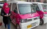 ?? AFP file ?? A driver with the women-only Paxi walks past a Pink Taxi during a launching ceremony in Karachi in March. —