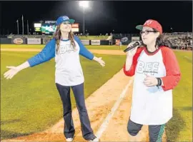  ??  ?? DAVIS AND O’DONNELL rev up the crowd at “A League of Their Own’ reunion event that included a screening of the 1992 film at Arvest Park in Bentonvill­e.