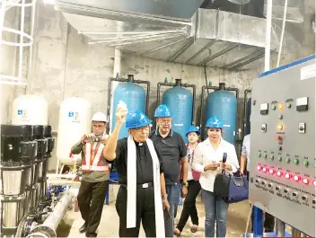  ?? CONTRIBUTE­D FOTO ?? BLESSING. Fr. Mar Alingasa of Cebu Uniting for Sustainabl­e Water blesses the water treatment facility with holy water as MRII chairman Antonio Tompar and MRII consultant Nerissa SoonRuiz join him.