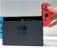  ?? AP ?? A model puts the controller onto the Nintendo Switch during a presentati­on event of the new Nintendo Switch in Tokyo. The Switch is a gutsy attempt by Nintendo to reclaim its territory in both the home and portable markets.—