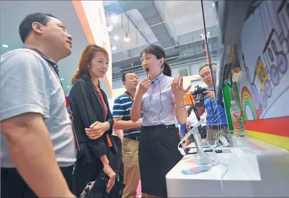  ?? WANG HAIBIN / FOR CHINA DAILY ?? A China Unicom employee introduces the company’s “internet plus education” app targeting children at an exhibition in Qingdao, Shandong province.