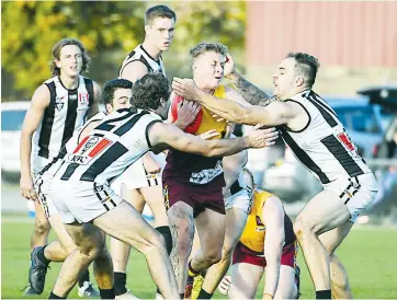  ??  ?? Will Leslie (left) and Luke Di Ciero (right) do their best to tackle Jackson Kos who tries to burst through the pack for Drouin.