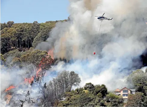  ?? MARTIN DE RUYTER, ROSA WOODS/STUFF ?? Home owners fled as a new fire broke out yesterday on Walters Bluff above Iwa Rd, Nelson; below right, Takaka volunteer firefighte­rs Callum Reid, front, and Grant Lawrence are exhausted at the end of their shift fighting the out-of-control forest fire that started in Pigeon Valley; below left, people watch the flames advance on Wakefield from Katania Heights, Brightwate­r, late on Thursday night.