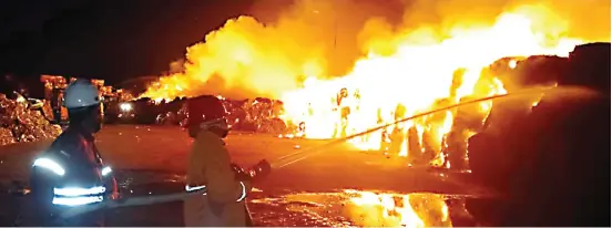 ?? AGEN BENCANA BPBD JATIM ?? DILALAP API: Petugas pemadam kebakaran memadamkan api tempat penyimpana­n bahan baku di pabrik kertas PT Tjiwi Kimia di Krian, Sidoarjo, kemarin (31/8).