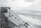  ?? Associated Press ?? n A house rests on the beach Friday after collapsing off a cliff from Hurricane Irma in Vilano Beach, Fla. Florida’s economy has long thrived on one major import: people. Irma raised concerns about just how sustainabl­e the allure of Florida’s...