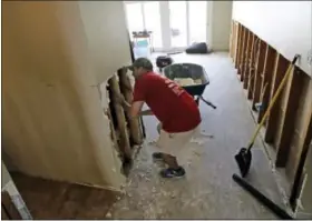  ?? DAVID J. PHILLIP — THE ASSOCIATED PRESS ?? David Cummings removes drywall from his home in the aftermath of Harvey Wednesday, Aug. 30, 2017, in Houston. Harvey did not discrimina­te in its destructio­n. It raged through neighborho­ods rich and poor, black and white, upscale and working class....