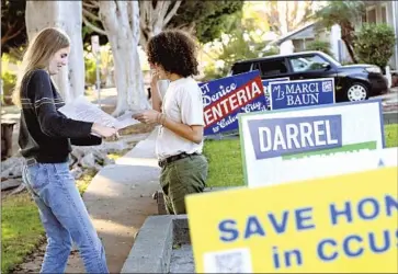  ?? CULVER CITY Wally Skalij Los Angeles Times ?? high school senior Ada Meighan-Thiel, left, hands out informatio­n last week on a ballot measure that would lower the voting age in her hometown. Measure VY is the only such effort on ballots this year.