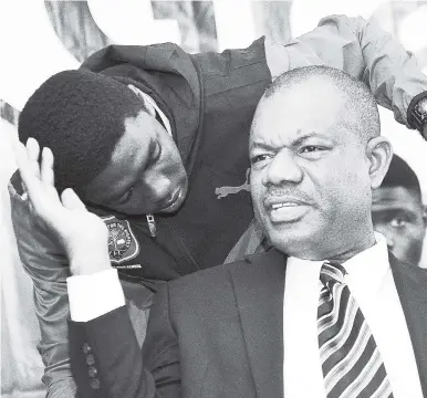  ?? FILE ?? Calabar principal Albert Corcho chats with a member of the school’s track team on Monday, March 26. Calabar has set a rigid 60 per cent average as a benchmark for boys to be promoted to higher grades, barring which their parents have been asked to place their kids elsewhere.