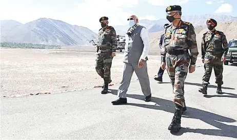  ?? — AFP photo ?? Modi (centre) walks with arrives in Leh, the joint capital of the union territory of Ladakh.