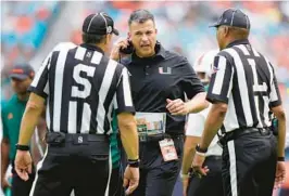  ?? WILFREDO LEE/AP ?? Miami head coach Mario Cristobal, center, argues a call with officials during the first half of Saturday’s loss to Duke.