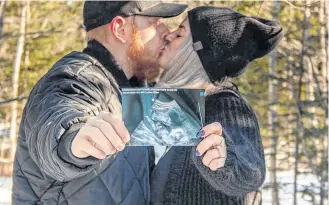  ??  ?? Kayla Beaver and her fiancé Cody Conway hold a photo of their unborn baby, captured during an ultrasound, in February. Conway will be the only person allowed to join Beaver during and after her delivery at the IWK Health Centre as visitor restrictio­ns at the hospital have tightened amid the coronaviru­s pandemic. COURTNEY HAMILTON