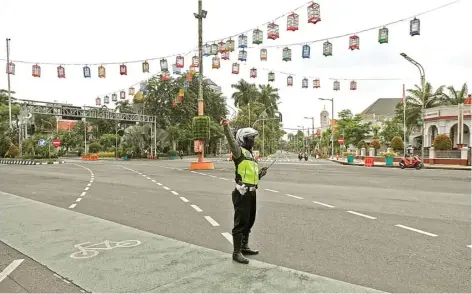  ?? DIPTA WAHYU/JAWA POS ?? TEGASKAN IMBAUAN: Polisi berjaga di persimpang­an Jalan Raya Darmo-Jalan dr Soetomo yang lengang karena penutupan jalan kemarin siang.