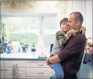  ??  ?? Tomasz Kruczek, hugs his son Gabriel at their Fremont home. Kruczek and his wife are worried that Gabriel is having a hard time adjusting since the family moved.