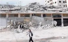  ?? — AFP ?? A Palestinia­n walks near the rubble of buildings demolished by Israeli army bulldozers, reportedly on grounds that constructi­on had no permits, in the occupied West Bank town of Qalandia on Wednesday.