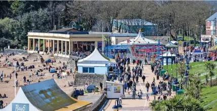  ?? MARK LEWIS ?? Visitors enjoy the sunny Easter Saturday weather at Barry Island yesterday, with car parks full (below right)