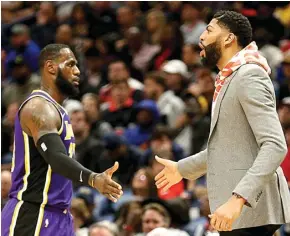  ?? AP PHOTO/RUSTY COSTANZA ?? TOS: Forward Los Angeles Lakers LeBron James (kiri) bersalaman dengan rekan setimnya, Anthony Davis, pada laga kontra New Orleans Pelicans Senin (2/3).