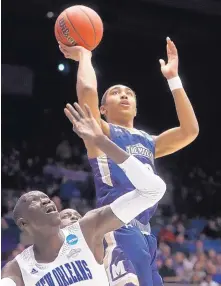  ?? JOHN MINCHILLO/ASSOCIATED PRESS ?? Mount St. Mary’s Miles Watson, right, shoots over New Orleans’ Makur Puou in the first half of Tuesday’s NCAA Tournament game in Dayton, Ohio. Mount St. Mary’s won 67-66.