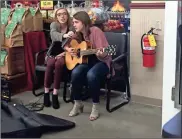  ?? / Jasmine Rothman ?? Bekah Pitts, left, and Allie Thomas provided live entertainm­ent during the opening of the Rossville Food City.