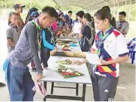  ??  ?? PARA peserta memasak makanan menggunaka­n kaedah Backwood Cooking.