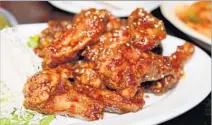  ??  ?? “I FEEL like I’m at home,” says Zone of the sticky-sweet wings with a sprinkling of sesame seeds at OB Bear in Koreatown.