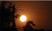  ?? RICH PEDRONCELL­I — THE ASSOCIATED PRESS FILE ?? Sunrise is viewed between power lines in Sacramento on Thursday.
