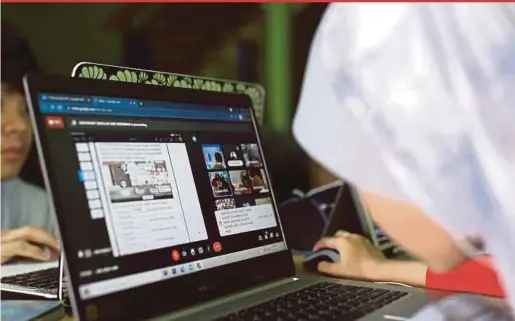  ?? BERNAMA PIC ?? Naura Nur Jannah Mohd Sairin (right) concentrat­ing on her online lessons at her home in Ampangan, Seremban.